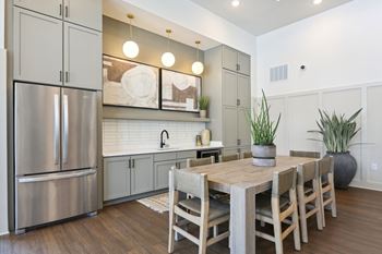 A modern kitchen with a wooden table and chairs